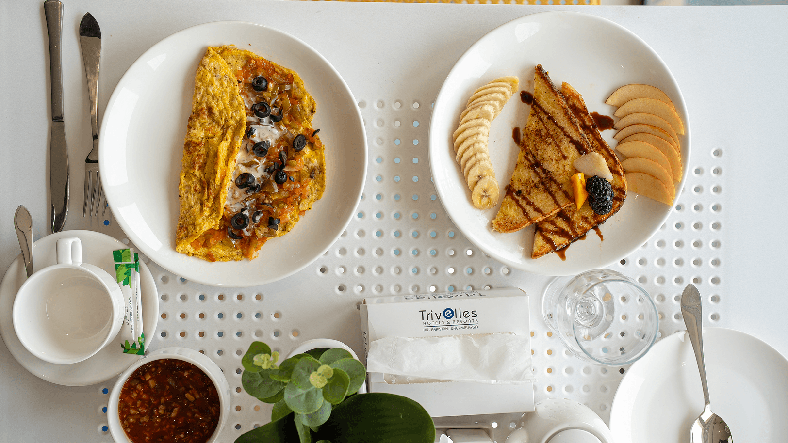 Overhead shot of Cyrus One breakfast spread with a vegetable omelette and banana-and-apple-topped French toast